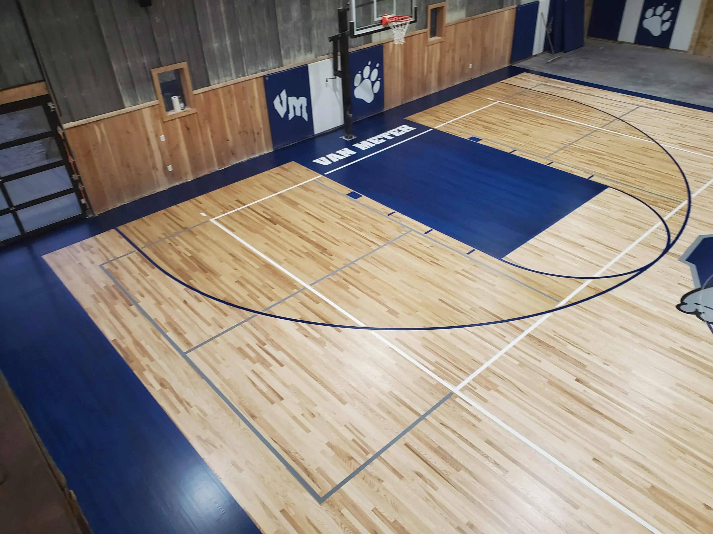 A basketball court with blue mats and wooden floors.