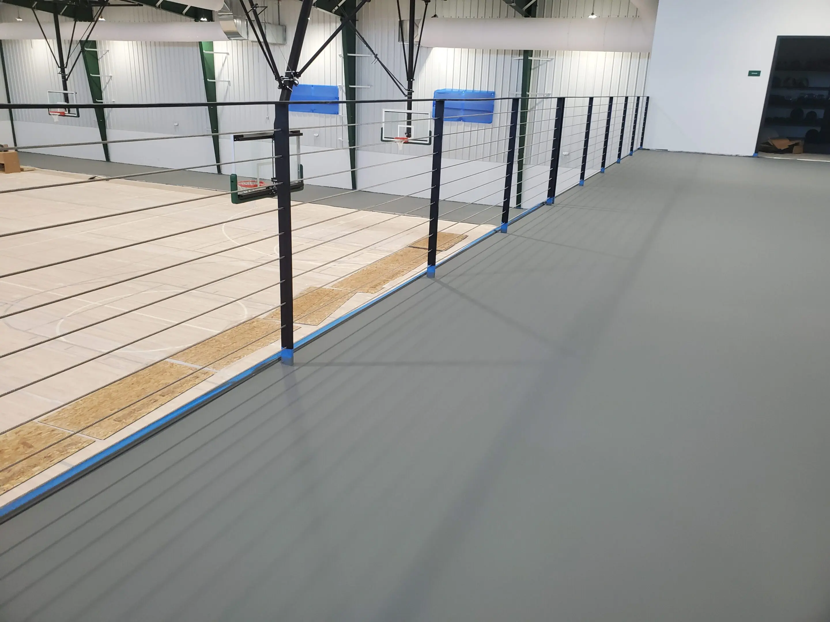 A gym with some fencing and a basketball court