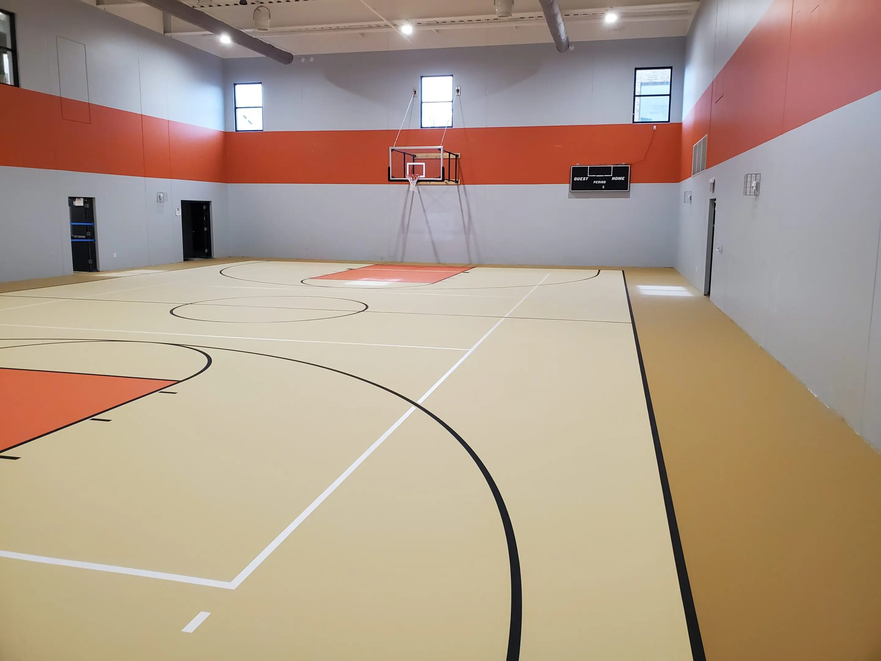 A basketball court with orange walls and white lines.