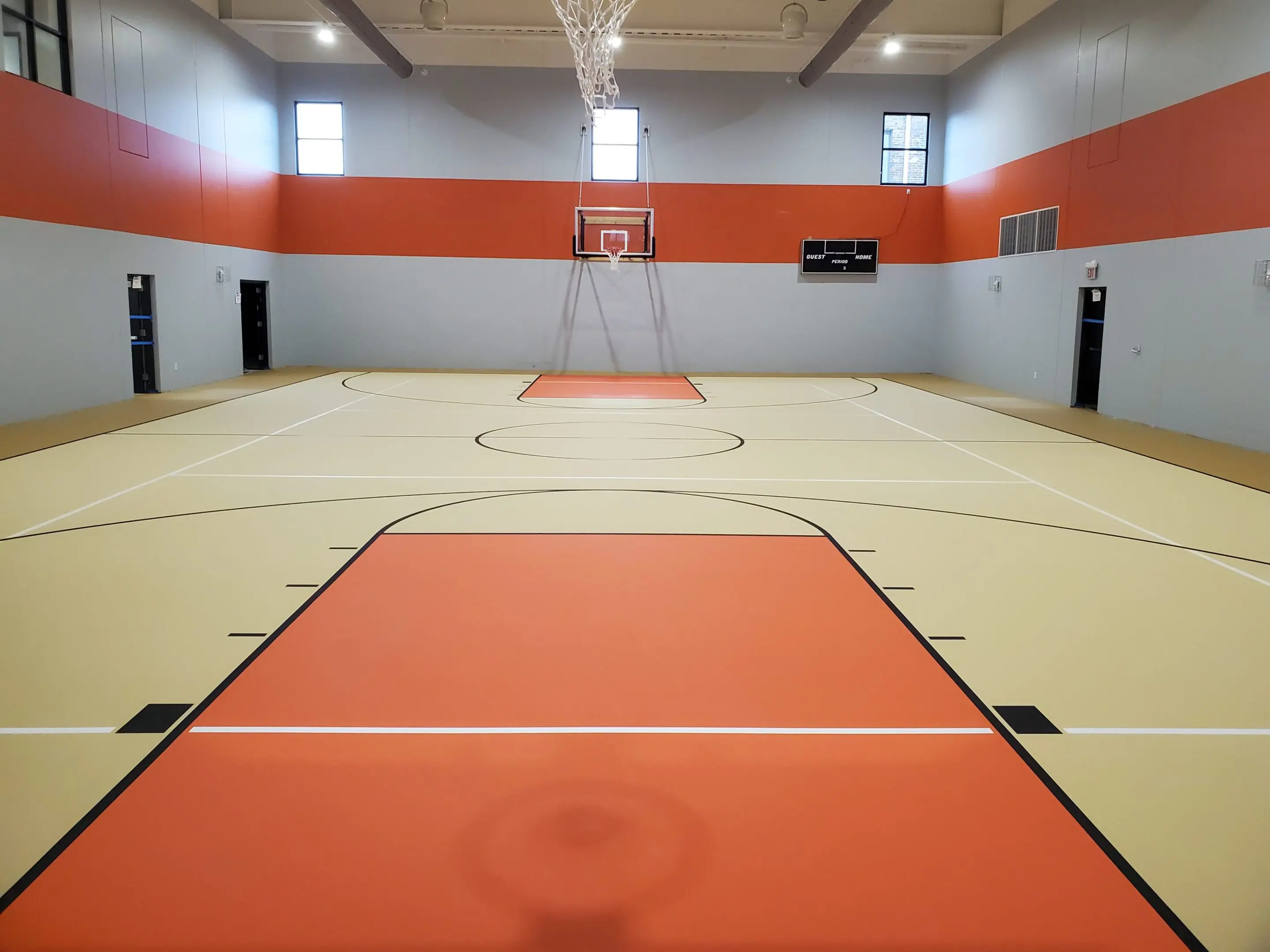 A basketball court with orange walls and white lines.