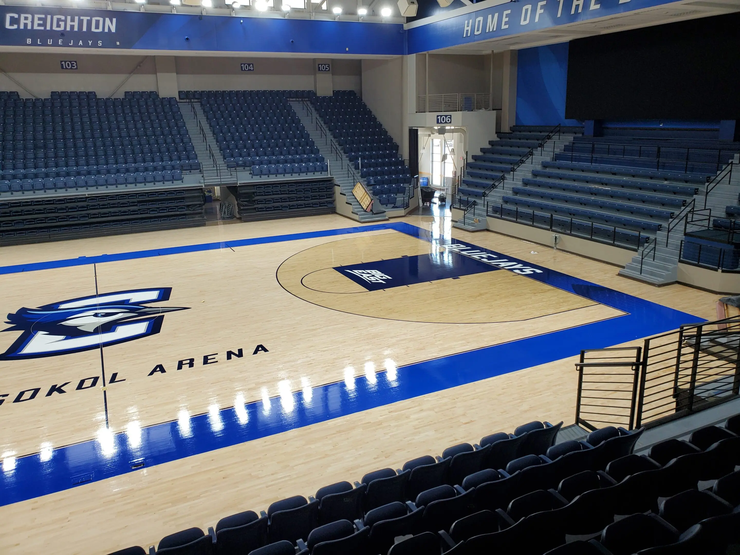 A basketball court with seats and lights in the middle.