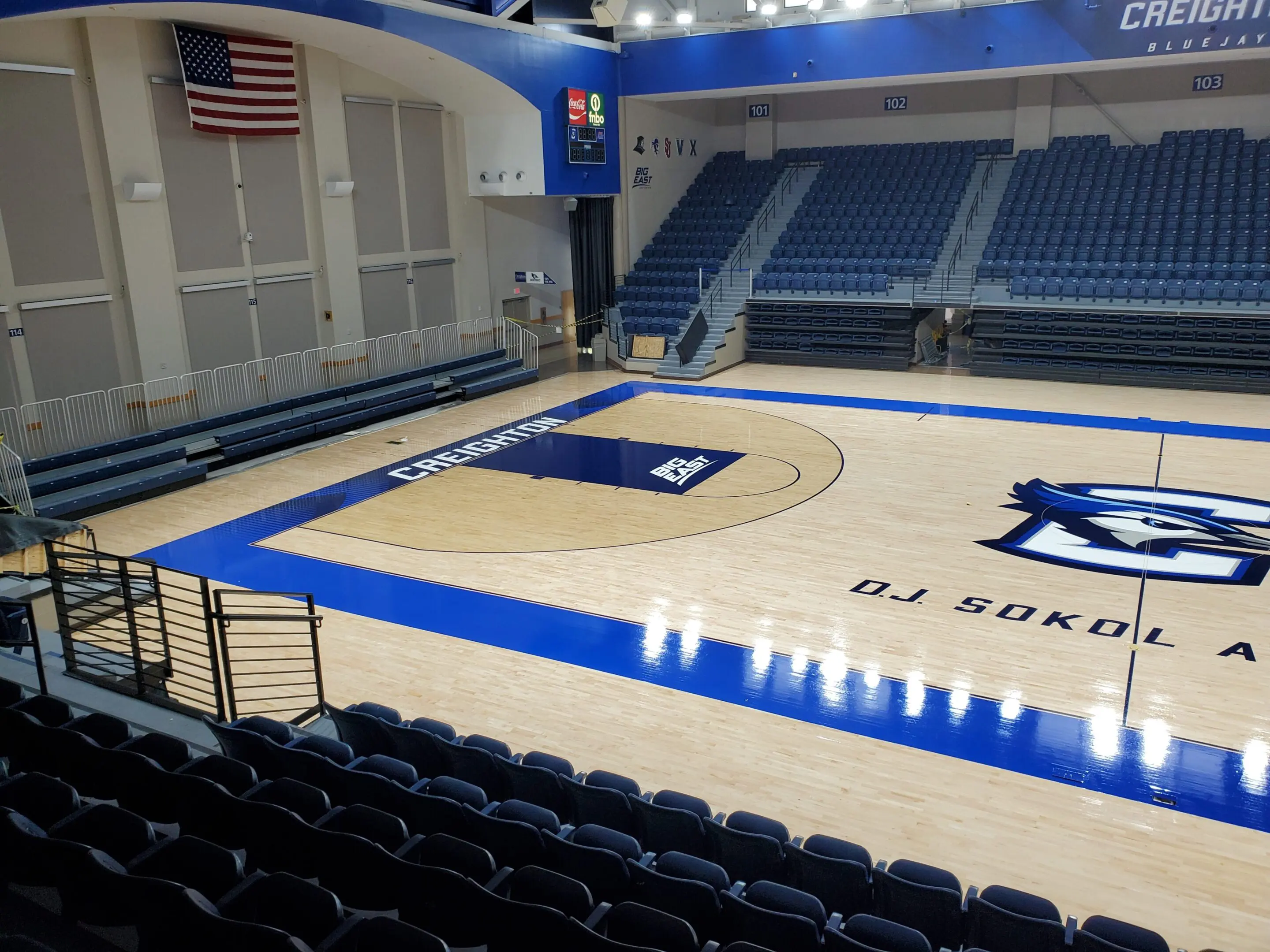 A basketball court with seats and a large floor.