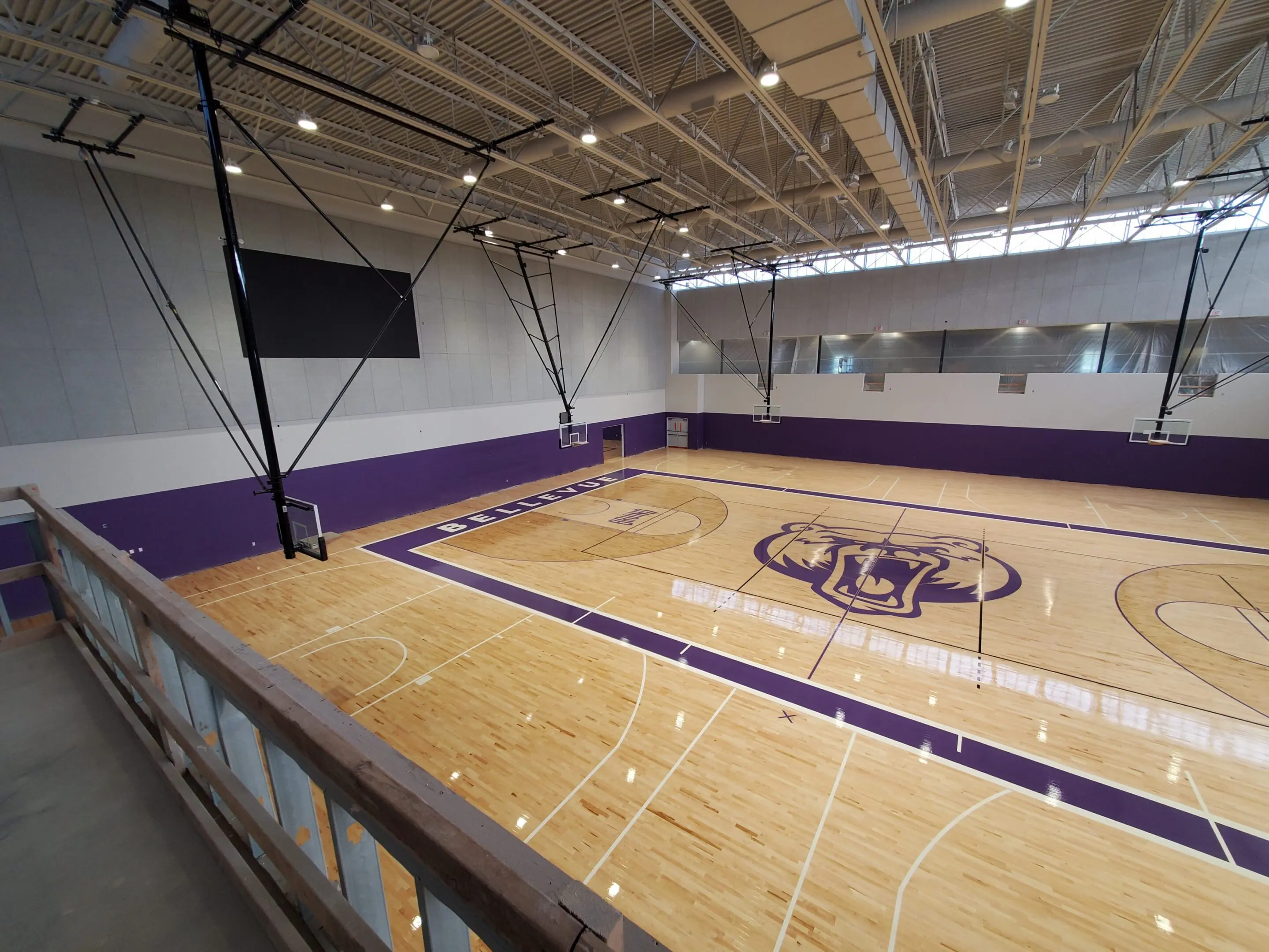 A basketball court with a large screen in the middle.