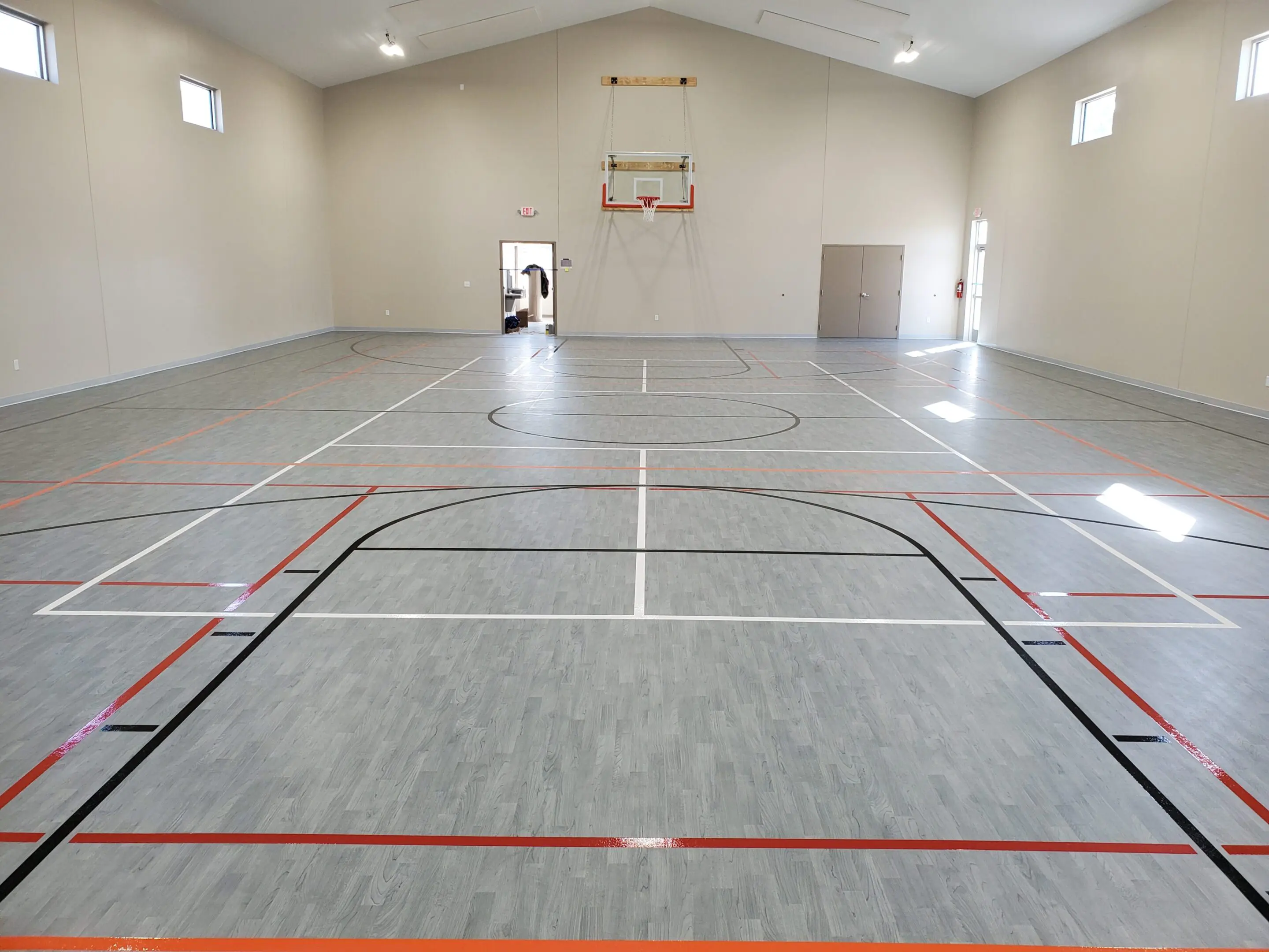 A basketball court with a person standing on the floor.