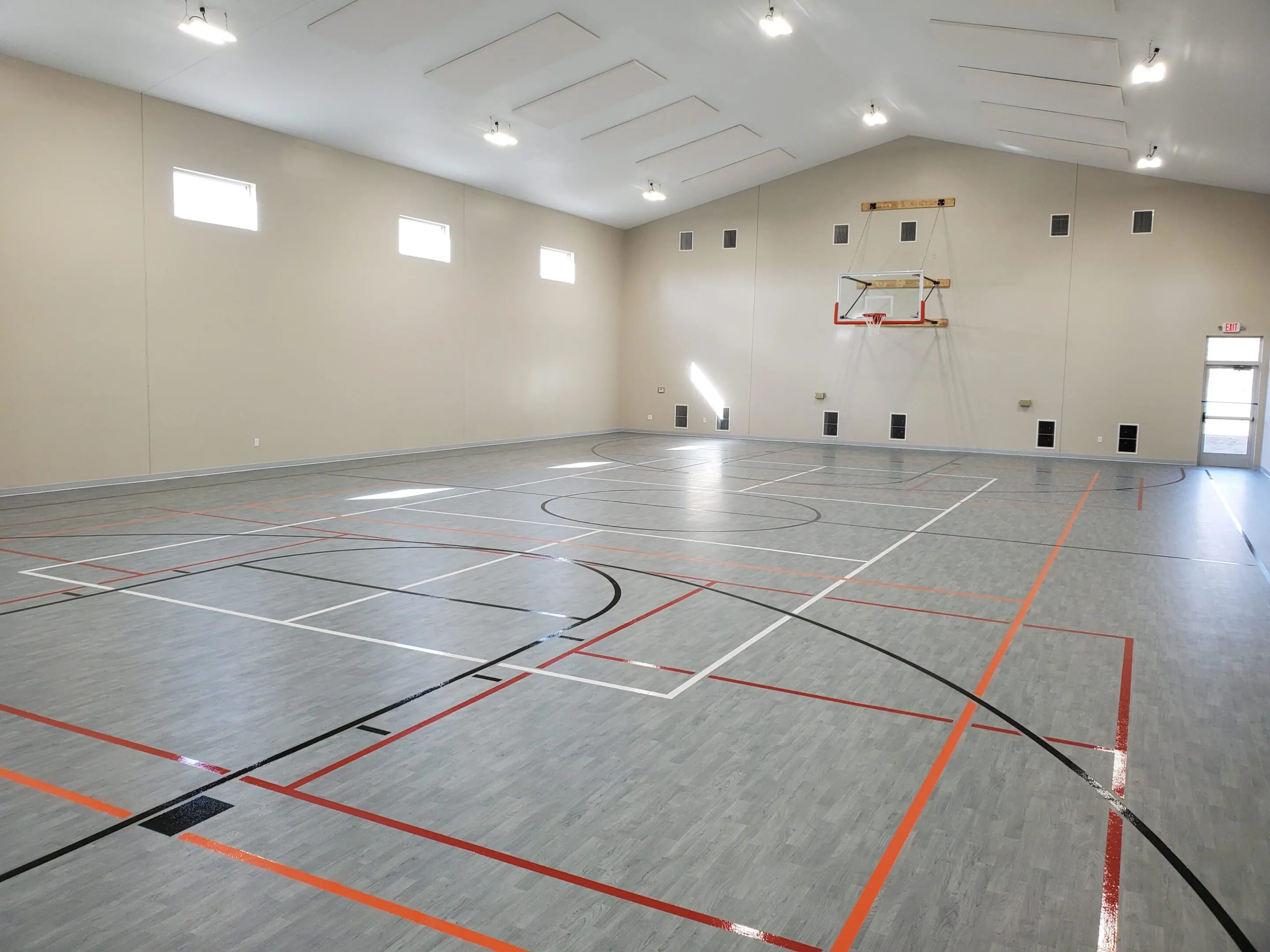 A gym with basketball hoops and a large room.