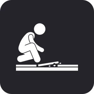 Gym Floor Installation Icon of a person kneeling to clean or repair a surface, holding a tool against the floor with debris nearby, on a dark background.